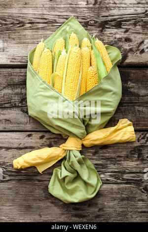 Bouquet of corn. Creative layout made of corn. Flat lay. Food concept. Ripe, sweet, fresh corn on cobs on rustic wooden table, top view Stock Photo