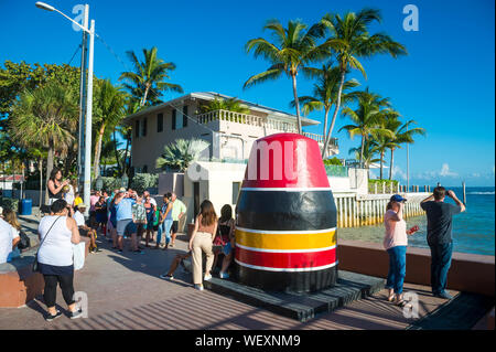 KEY WEST, FLORIDA, USA - JULY 27, 2019: Tourists take photos at the colorful buoy marking the southernmost point of the continental United States. Stock Photo