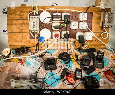 Chargers and adapters for the expedition's radios cluster around the only power outlet at the Peak Lenin base camp in Kyrgyzstan. Wifi there costs two US dollars per hour. Stock Photo