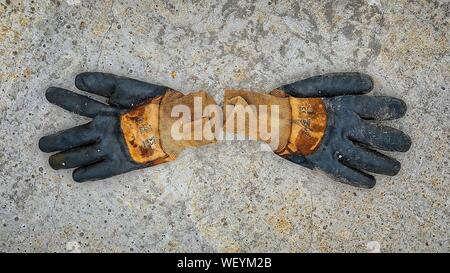 A pair of old work gloves over a reinforced concrete slab, at construction site Stock Photo