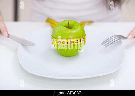 Diet. Apple and centimeter on the plate. Fitness healthy eating Stock Photo
