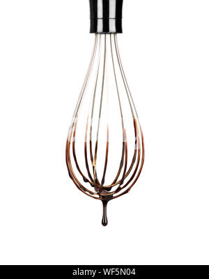Cookery wire whisk with splashing chocolate isolated on white background with clipping path. Chocolate drop Stock Photo