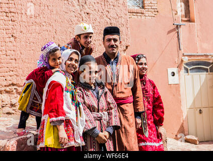 Happy Family Wearing Traditional Clothing Standing Against Wall