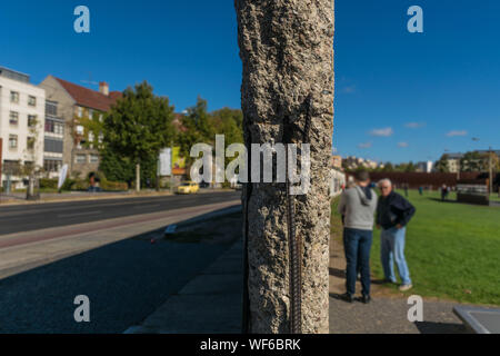 Divided picture with a close up on the structure of a concrete wall of the Berlin Wall Memorial at the Memorial Park, in Germany, one side showing a r Stock Photo