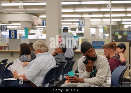 Wethersfield, CT / USA - June 11, 2019: Snapshot of a bored crowd of people in the waiting area (focus on african american man) Stock Photo