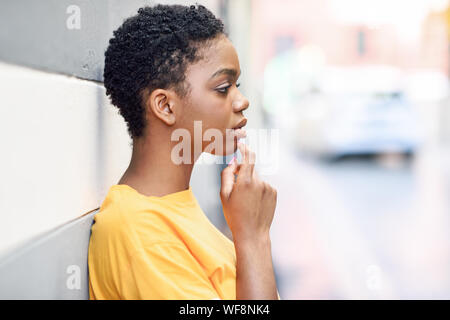 Thoughtful black woman with sad expression outdoors.