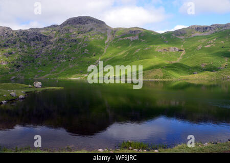 The Wainwright Tarn Crag and Easedale Tarn in the Lake District National Park, Cumbria, England, UK Stock Photo