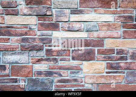 Block stone wall background in warm tones. Stock Photo