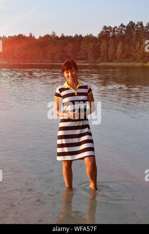 Beautiful and charming young woman. In the open air. Standing in the lake water Stock Photo