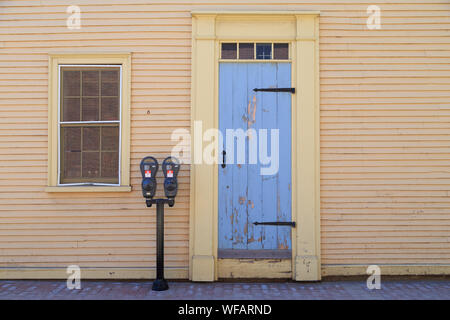 The house with blue door built in the 18th century on the cobblestone street accompanied with 20th century parking meter in Portsmouth, New Hampshire. Stock Photo