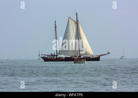 The beautiful scenery of traditional fisherman sailing ship when it is seen over the sea on Volendam waters in the summer. Stock Photo