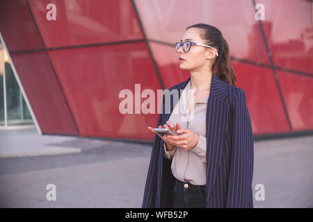 Woman hesitates to make a phone call. Doubt, indecision concept Stock Photo