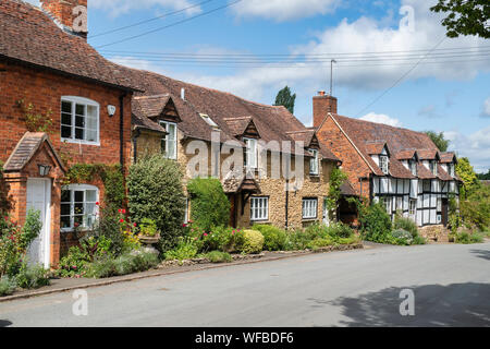 Red brick, stone and black and white timber framed cottage and garden. Elmley Castle, Cotswolds, Wychavon district, Worcestershire, England Stock Photo