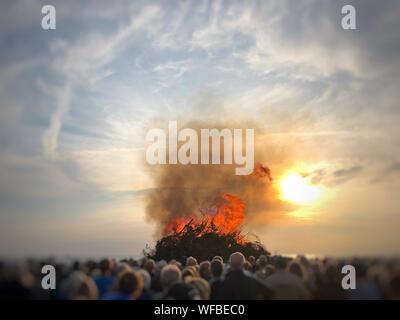 People watching a bonfire on the beach at midsummer, Fanoe, Denmark Stock Photo