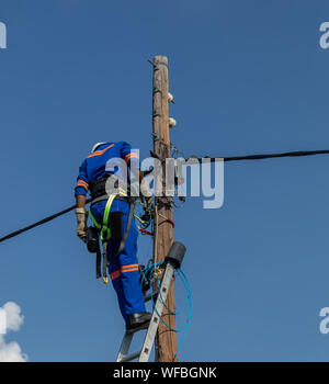 electrician worker in a Botswana , working on a pole to repair a fault Stock Photo