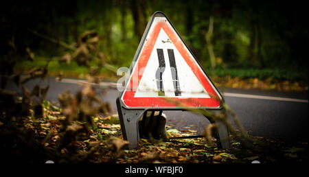 Road narrows on left road warning sign - UK highway code Stock Photo