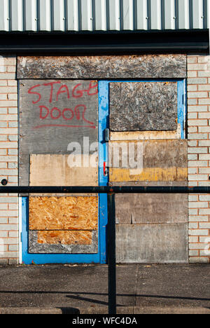'Stage door' grafitti spray-painted in red on a boarded-up door of a disused factory Stock Photo