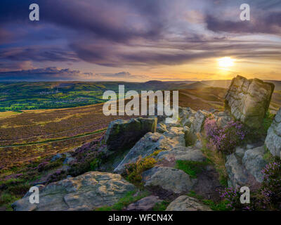 Win Hill, UK - Aug 12, 2019:  Colourful sunset over the Peak District from Win Hill with the beginnings of heather blossoming. Stock Photo