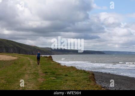 Ceredigion coastal path, near Llanon, Ceredigion, Wales, UK 31st August 2019 UK weather: A woman walking along the Ceredigion coastal path between Llanon and Aberaeron in mid Wales. As the weather stays windy but the early morning rain having now eased off: Credit: Ian Jones/Alamy Live News Stock Photo