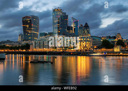 Night view of skyscrapers of the City of London over the Thames , England