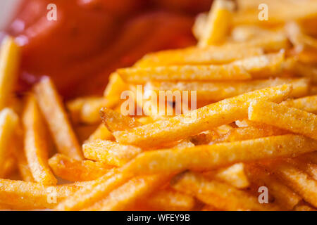 Closeup of french fries corn snacks sticks with ketchup Stock Photo