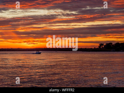 An amazing sunset with a power boat underway and the North Fork in the background Stock Photo