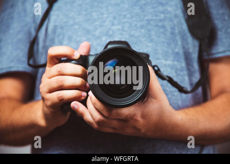 Close up of man hands holding DSLR Camera - Man photograph with camera Stock Photo