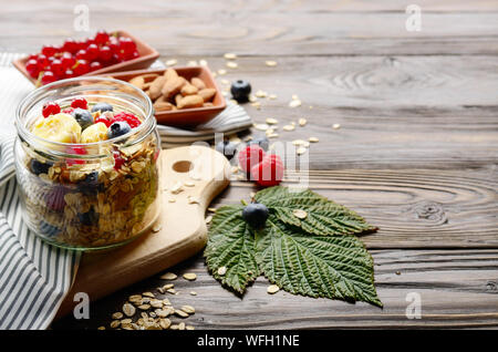 Fruit healthy muesli in glass jar on kitchen wooden table Stock Photo