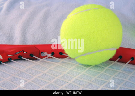 Tennis balls on a racquet. Tennis equipment. New tennis balls. Stock Photo