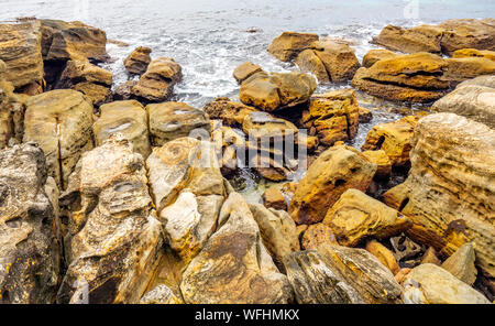 Eroded rocks at the shoreline at Cabbage Tree Bay Manly Sydney NSW Australia. Stock Photo