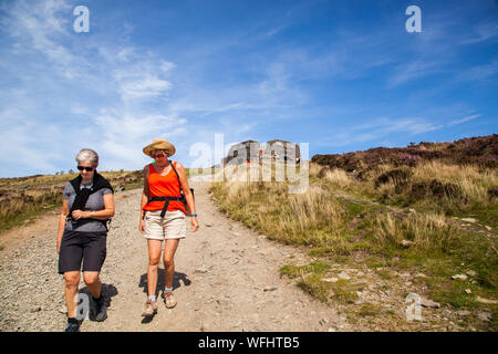 Men women children and families walking Offas Dyke footpath in the Clwydian Hills near the Jubliee Tower on the summit of Moel Famau  mountain Wales Stock Photo