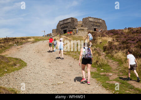 Men women children and families walking Offas Dyke footpath in the Clwydian Hills near the Jubliee Tower on the summit of Moel Famau  mountain Wales Stock Photo