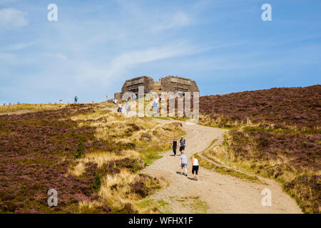 Men women children and families walking Offas Dyke footpath in the Clwydian Hills near the Jubliee Tower on the summit of Moel Famau  mountain Wales Stock Photo
