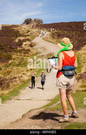 Men women children and families walking Offas Dyke footpath in the Clwydian Hills near the Jubliee Tower on the summit of Moel Famau  mountain Wales Stock Photo