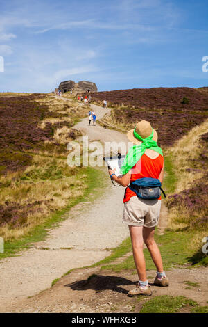 Men women children and families walking Offas Dyke footpath in the Clwydian Hills near the Jubliee Tower on the summit of Moel Famau  mountain Wales Stock Photo