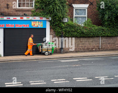 Man in High Vis safety wear with street cleaning cart Stock Photo