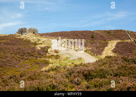 Men women children and families walking Offas Dyke footpath in the Clwydian Hills near the Jubliee Tower on the summit of Moel Famau  mountain Wales Stock Photo
