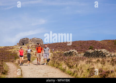 Men women children and families walking Offas Dyke footpath in the Clwydian Hills near the Jubliee Tower on the summit of Moel Famau  mountain Wales Stock Photo