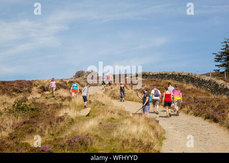 Men women children and families walking Offas Dyke footpath in the Clwydian Hills near the Jubliee Tower on the summit of Moel Famau  mountain Wales Stock Photo