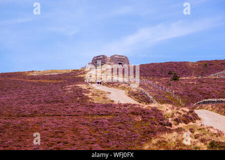 Men women children and families walking Offas Dyke footpath in the Clwydian Hills near the Jubliee Tower on the summit of Moel Famau  mountain Wales Stock Photo