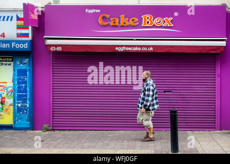 man walking near closed shuttered shop in Rotherham Stock Photo