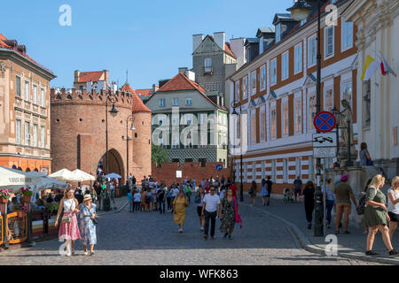 Warsaw, Poland – August, 2019 : Tourists on the street with Warsaw Barbican, Historical landmark sightseeing in Poland Stock Photo