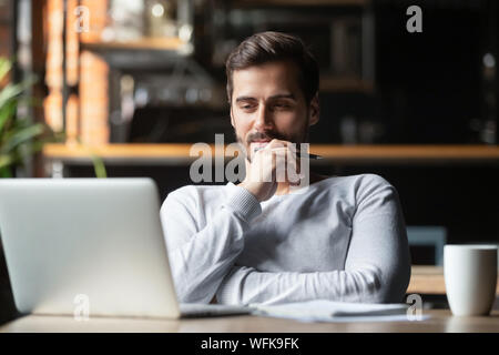 Thoughtful businessman think of online project looking at laptop Stock Photo