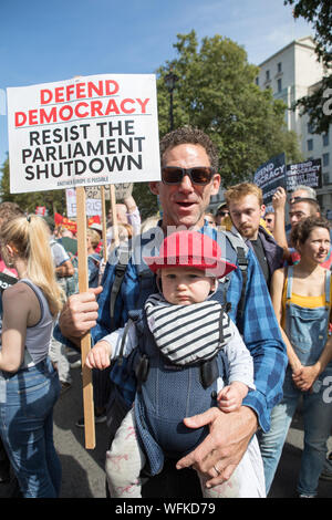 Whitehall, London, UK. 31 August 2019. Father and baby son (Dillon Smith & Leo) take part to the demonstration opposite Downing Street. Thousands of protesters have taken to the streets in cities across the UK, including London to demonstrate against Boris Johnson’s decision to suspend Parliament in the run up to Brexit. Demonstrators included a number of MPs, celebrities and political commentators who spoke against proroguing Parliament. Stock Photo