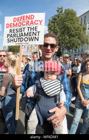 Whitehall, London, UK. 31 August 2019. Father and baby son (Dillon Smith & Leo) take part to the demonstration opposite Downing Street. Thousands of protesters have taken to the streets in cities across the UK, including London to demonstrate against Boris Johnson’s decision to suspend Parliament in the run up to Brexit. Demonstrators included a number of MPs, celebrities and political commentators who spoke against proroguing Parliament. Stock Photo