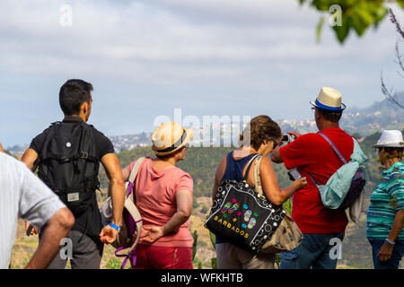 FUNCHAL, PORTUGAL - JULY 14, 2017: Hiking tourists from behind enjoying the view Stock Photo