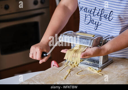 Midsection Of Young Woman Making Fresh Pasta At Home Stock Photo