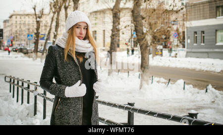 Portrait Of Young Woman Wearing Warm Clothing In City During Winter