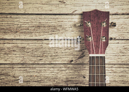 head of a pink ukulele on a white wooden background in vintage style with copy space Stock Photo