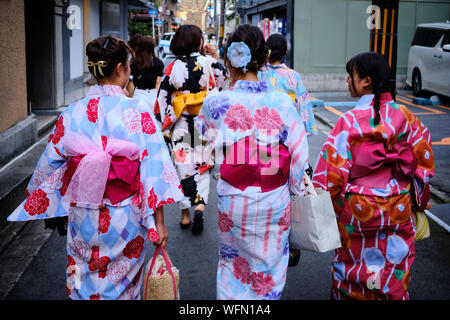 Japanese women dressed in kimonos walk along a street in Kyoto, Japan on a shopping trip Stock Photo